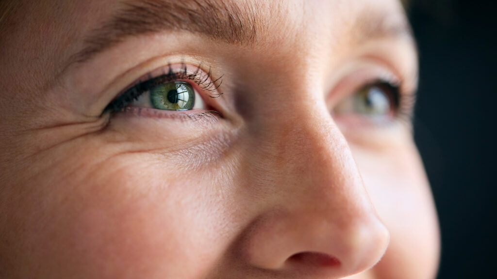 Macro Studio Expression Shot Of Woman's Smiling Eyes With Close Up On Eyelashes And Pupil